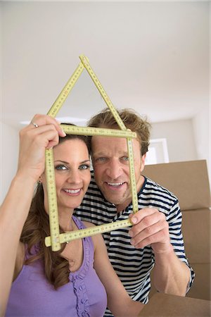 Couple holding yardstick shape house new Stock Photo - Premium Royalty-Free, Code: 6121-07809987