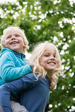 Young blonde girl carrying brother piggyback Foto de stock - Sin royalties Premium, Código: 6121-07809923