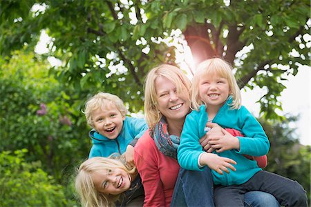 Mother playing with three young kids in garden Foto de stock - Sin royalties Premium, Código: 6121-07809937