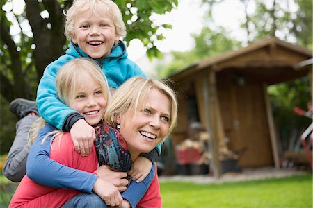 Mother playing garden with young kids piggyback Foto de stock - Sin royalties Premium, Código: 6121-07809935