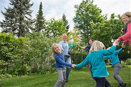 Parents and children dancing on garden lawn Foto de stock - Sin royalties Premium, Código: 6121-07809938