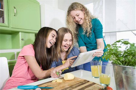 funny looking girls with glasses - Girls in kitchen with digital tablet, preparing vegetables Stock Photo - Premium Royalty-Free, Code: 6121-07810133