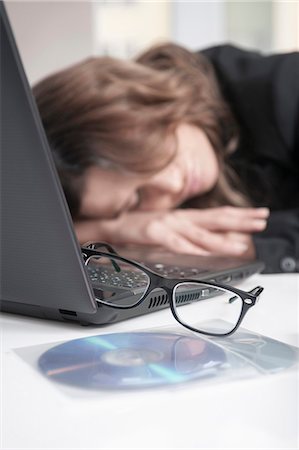 disque compact - Young over-burdened businesswoman sleeping at her workplace Photographie de stock - Premium Libres de Droits, Code: 6121-07810240