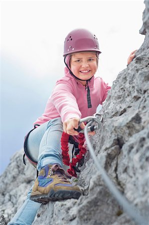 Teenage girl climbing attaching carabiner to rope Foto de stock - Sin royalties Premium, Código: 6121-07810280