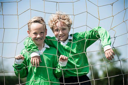 Two young football players posing in goal Stock Photo - Premium Royalty-Free, Code: 6121-07810305