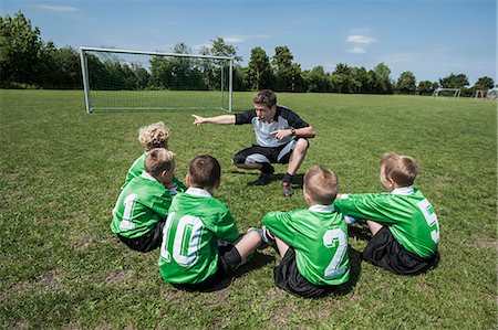 Football coach talking to young boys team Stock Photo - Premium Royalty-Free, Code: 6121-07810308