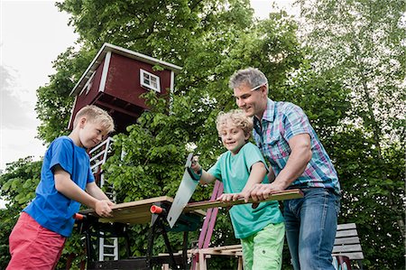 Boy sawing wood building father helping Stockbilder - Premium RF Lizenzfrei, Bildnummer: 6121-07810401