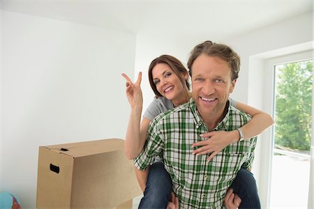 Woman piggyback man new house happy Stock Photo - Premium Royalty-Free, Code: 6121-07970098