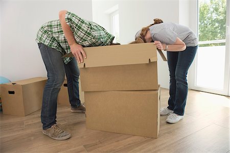 Man woman looking searching inside box Stock Photo - Premium Royalty-Free, Code: 6121-07970099