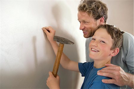 strike - Smiling father son working together hammer wall Foto de stock - Sin royalties Premium, Código: 6121-07970002