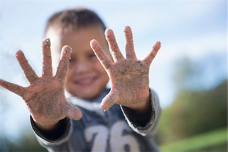 Small boy showing hands covered sand playground Foto de stock - Sin royalties Premium, Código: 6121-07970107