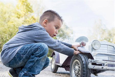 réplique (modèle) - Boy checking wheel model toy vintage car Photographie de stock - Premium Libres de Droits, Code: 6121-07970121