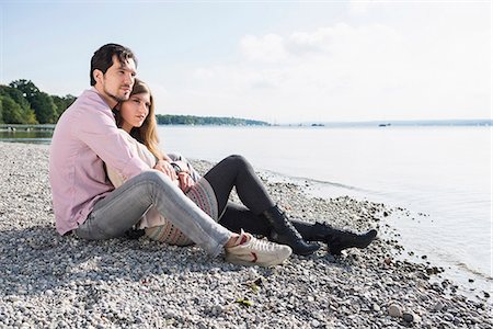 Loving young couple sitting shore lake Stock Photo - Premium Royalty-Free, Code: 6121-07992482