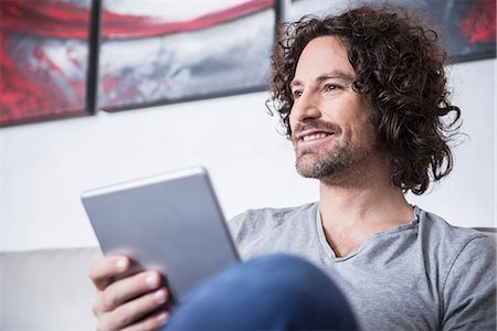 Man using a digital tablet at home, Munich, Bavaria, Germany Foto de stock - Sin royalties Premium, Código: 6121-07992591