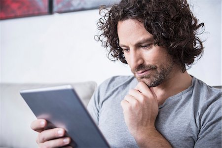 Man using a digital tablet at home, Munich, Bavaria, Germany Foto de stock - Sin royalties Premium, Código: 6121-07992592