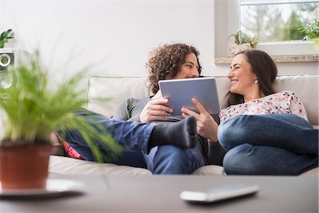 se regarder l'un l'autre - Couple using digital tablet at home, Munich, Bavaria, Germany Photographie de stock - Premium Libres de Droits, Code: 6121-08106523