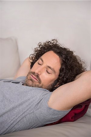 simple living - Mid adult man sleeping on couch, Munich, Bavaria, Germany Stock Photo - Premium Royalty-Free, Code: 6121-08106524