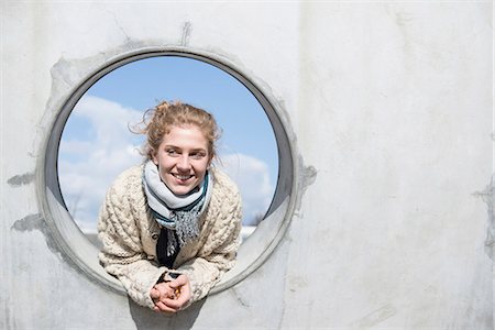Young woman looking through a round hole in concrete wall, Munich, Bavaria, Germany Foto de stock - Sin royalties Premium, Código: 6121-08106609