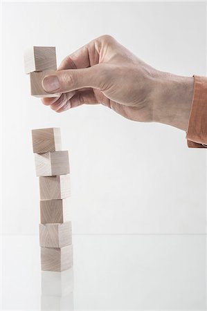 Man's hand stacking wooden building blocks, Bavaria, Germany Stock Photo - Premium Royalty-Free, Code: 6121-08106843