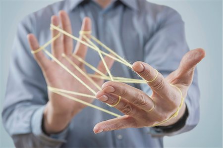 Mid section view of a man's hands making a cats cradle with string, Bavaria, Germany Stockbilder - Premium RF Lizenzfrei, Bildnummer: 6121-08106840