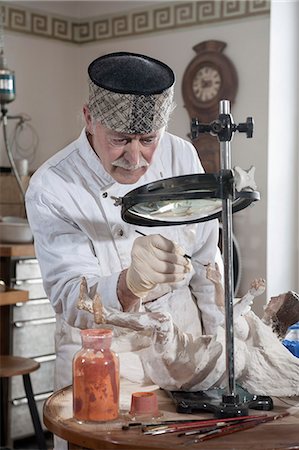 Senior sculptor colouring a Jesus Christ statue at workshop, Bavaria, Germany Stock Photo - Premium Royalty-Free, Code: 6121-08106803