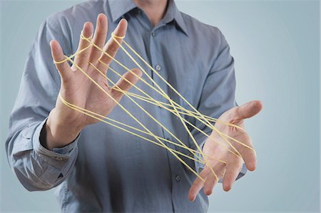 Mid section view of a man's hands making a cats cradle with string, Bavaria, Germany Stockbilder - Premium RF Lizenzfrei, Bildnummer: 6121-08106839