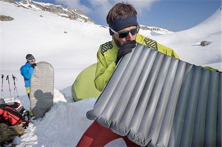 Two men blowing into air mattresses for camping, Tyrol, Austria Photographie de stock - Premium Libres de Droits, Code: 6121-08106990