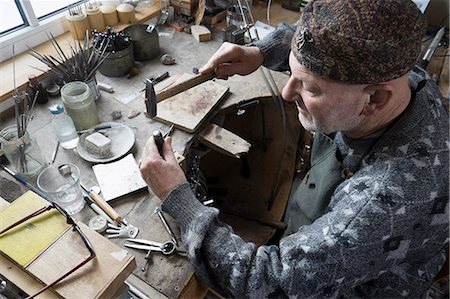Senior male goldsmith hitting punches in workshop, Bavaria, Germany Stock Photo - Premium Royalty-Free, Code: 6121-08106900