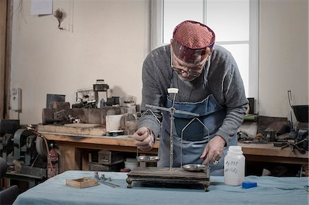 Senior male goldsmith weight silvers on scale at workshop, Bavaria, Germany Photographie de stock - Premium Libres de Droits, Code: 6121-08106938