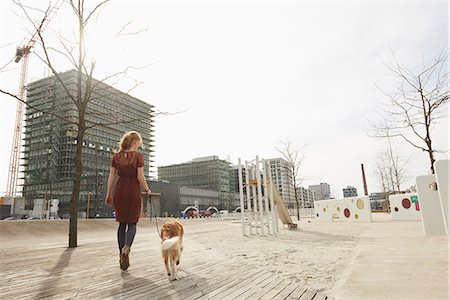 Rear view of a young woman walking in playground with dog, Munich, Bavaria, Germany Foto de stock - Sin royalties Premium, Código: 6121-08228528
