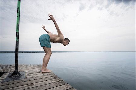 Mature man diving into water on pier, Bavaria, Germany Photographie de stock - Premium Libres de Droits, Code: 6121-08228743