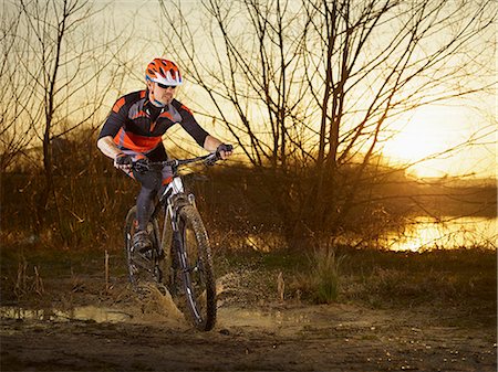 Mature man riding mountain bike on dirt track, Bavaria, Germany Foto de stock - Sin royalties Premium, Código: 6121-08228772
