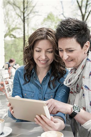dos personas - Two friends using digital tablet in the sidewalk cafe, Bavaria, Germany Foto de stock - Sin royalties Premium, Código: 6121-08228703