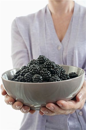 Mid section view of woman holding a bowl of blackberry, Bavaria, Germany Foto de stock - Sin royalties Premium, Código: 6121-08228735