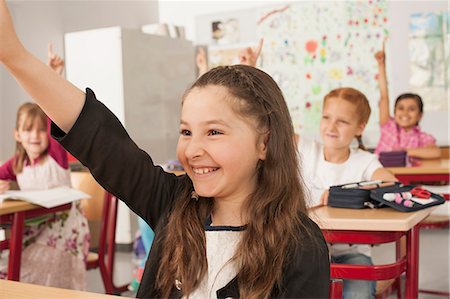 School children with raised hands in classroom, Munich, Bavaria, Germany Photographie de stock - Premium Libres de Droits, Code: 6121-08228948