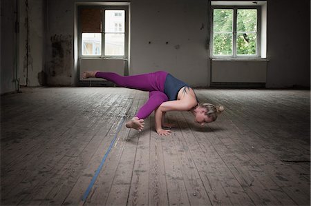 Mid adult woman practicing Eka pada koundinyasana I pose in Yoga Studio, Munich, Bavaria, Germany Foto de stock - Sin royalties Premium, Código: 6121-08228988