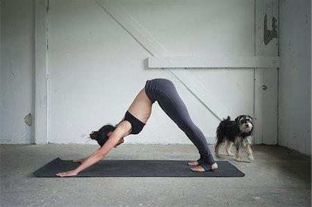 Mid adult woman practicing downward facing dog pose in yoga studio, Munich, Bavaria, Germany Foto de stock - Sin royalties Premium, Código: 6121-08228998