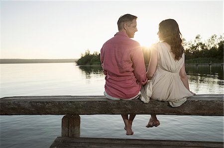 dangling - Mature couple looking at each other on pier at sunset, Bavaria, Germany Stock Photo - Premium Royalty-Free, Code: 6121-08361573