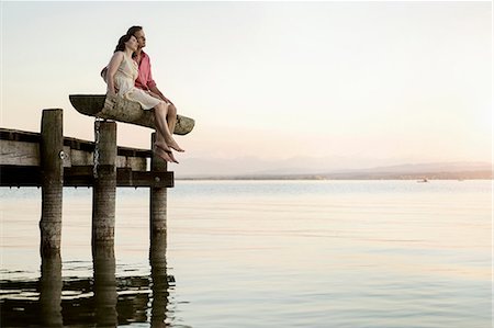 Mature couple sitting on pier looking over lake, Bavaria, Germany Stock Photo - Premium Royalty-Free, Code: 6121-08361580