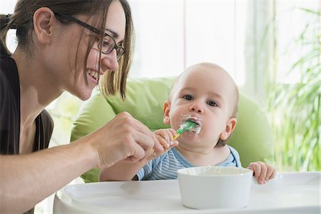 sucio - Mother feeding baby food to her baby boy with spoon, Munich, Bavaria, Germany Foto de stock - Sin royalties Premium, Código: 6121-08361523