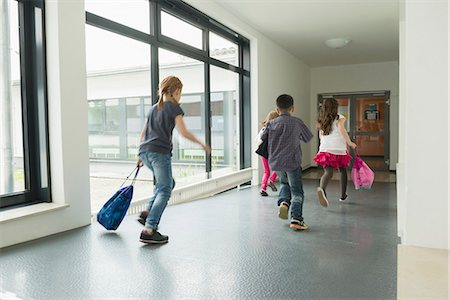 Children running with sports bags in corridor of sports hall, Munich, Bavaria, Germany Stock Photo - Premium Royalty-Free, Code: 6121-08361673
