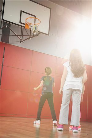 Girls playing basket ball in basketball court, Munich, Bavaria, Germany Stock Photo - Premium Royalty-Free, Code: 6121-08361676