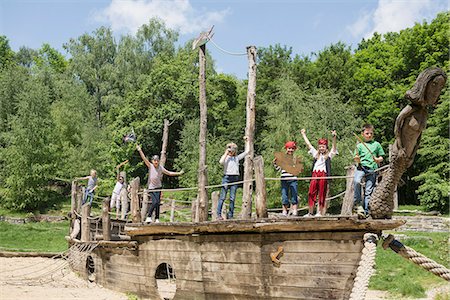 Group of children playing on a pirate ship in adventure playground, Bavaria, Germany Foto de stock - Sin royalties Premium, Código: 6121-08361631