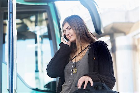 Young woman talking on mobile phone and standing in front of bus, Freiburg im Breisgau, Baden-Württemberg, Germany Photographie de stock - Premium Libres de Droits, Code: 6121-08361701