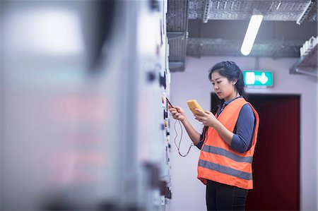reflective clothing - Young female engineer examining control panel with multimeter in an industrial plant, Freiburg im Breisgau, Baden-Württemberg, Germany Stock Photo - Premium Royalty-Free, Code: 6121-08522408