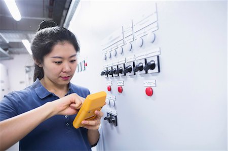 Young female engineer examining control panel with multimeter in an industrial plant, Freiburg im Breisgau, Baden-Württemberg, Germany Stock Photo - Premium Royalty-Free, Code: 6121-08522413