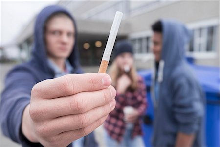 fumé - University student showing cigarette in campus, Bavaria, Germany Photographie de stock - Premium Libres de Droits, Code: 6121-08660422
