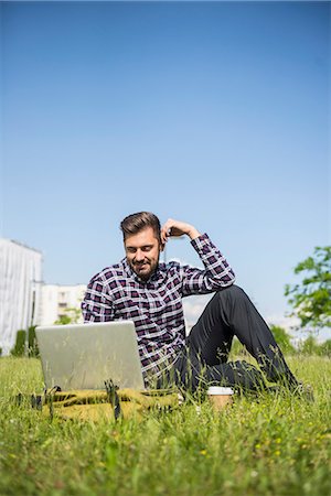 Young man working on laptop and sitting in park, Munich, Bavaria, Germany Photographie de stock - Premium Libres de Droits, Code: 6121-08859013