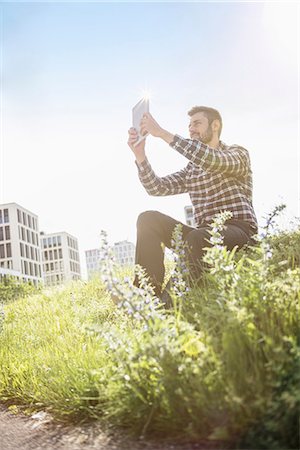 Young man taking self portrait photography with digital tablet in the park, Munich, Bavaria, Germany Foto de stock - Sin royalties Premium, Código: 6121-08859018