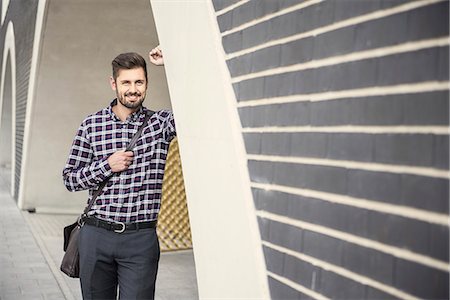 Young man leaning against round arch and smiling, Munich, Bavaria, Germany Stockbilder - Premium RF Lizenzfrei, Bildnummer: 6121-08859022